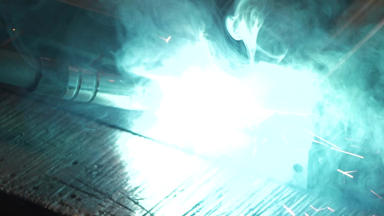 Welder works in metal construction - construction and processing of steel components, slow motion