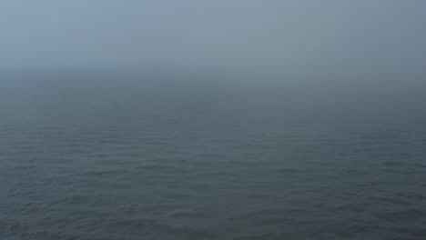 drone flying into foggy ocean