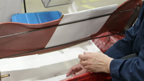 worker checking quality of caps made by automatic machine, close up