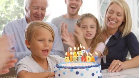 boy blows out candles on birthday cake, slow motion