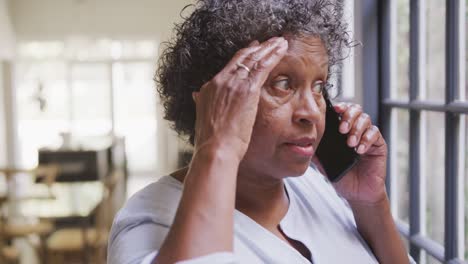 Senior-mixed-race-woman-using-a-smartphone.-Social-distancing-and-self-isolation-in-quarantine