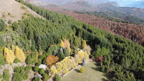 aerial backwards shot showing multicolored landscape of patagonia with cozy house in summer - bariloche,argentina