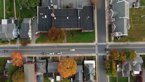 high aerial top-down drone shot of traffic on street through residential community neighborhood in usa