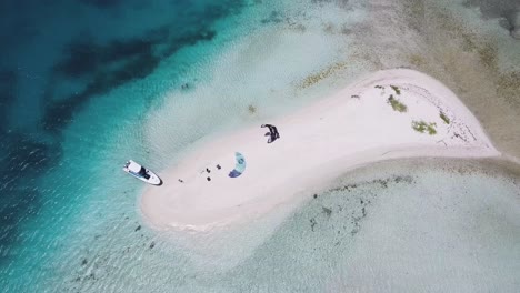 top down atoll with two kitesurfers on white sand beach to kitesurf in azure, los roques