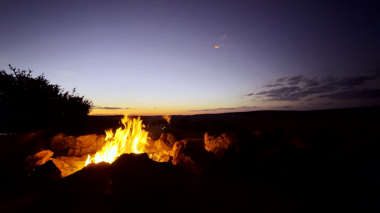 Roaring campfire with yellow flames in South African wilderness at twilight