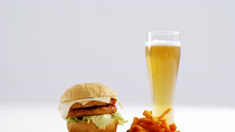 snacks and glass of beer against white background