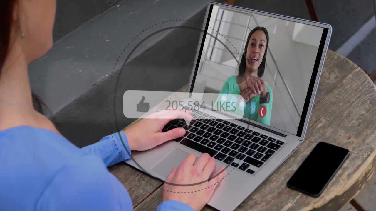Animation of speech bubble with thumbs up and numbers growing over woman using laptop on video call