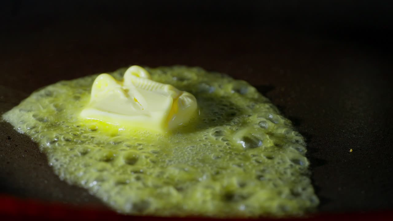 Macro view of butter melting texture with sizzling foam, hot frying pan closeup