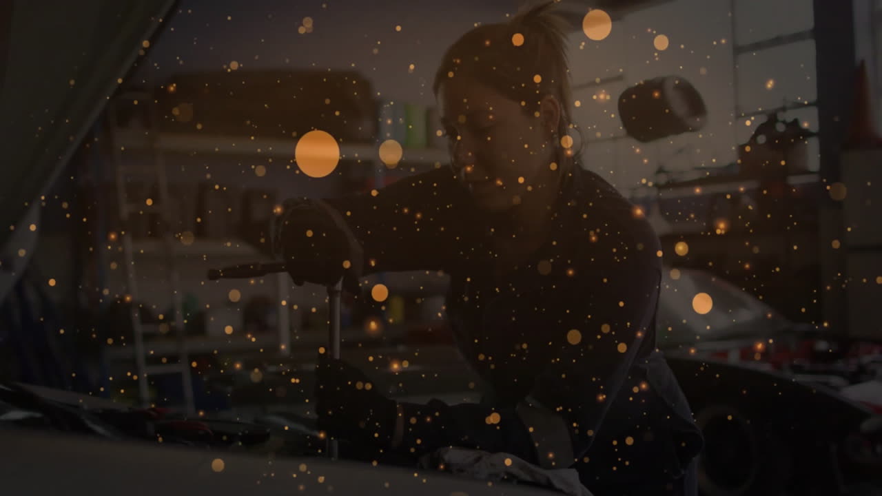 Woman auto-body mechanic polishing car panel in workshop, showcasing floating golden spark overlays