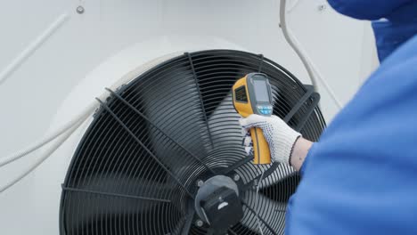 technician uses a thermal imaging infrared thermometer to check the condensing unit heat exchanger