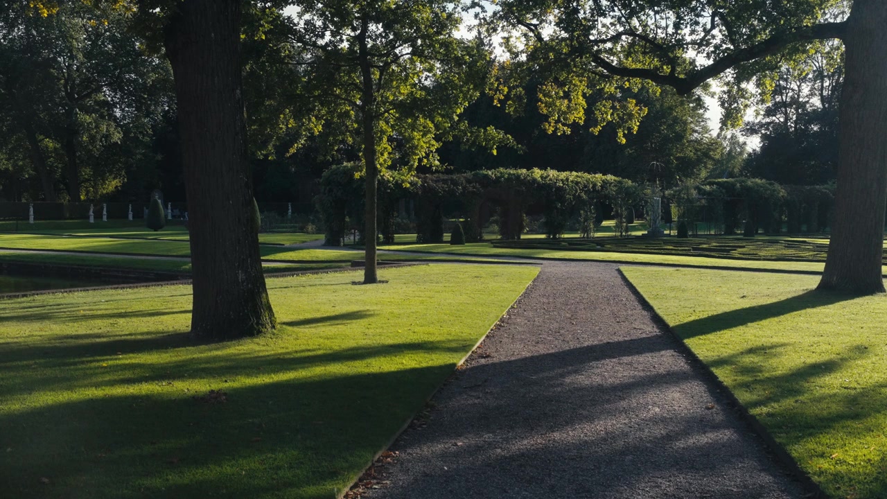 Un parco tranquillo immerso nel caldo bagliore del sole, catturato in un'inquadratura statica e serena.