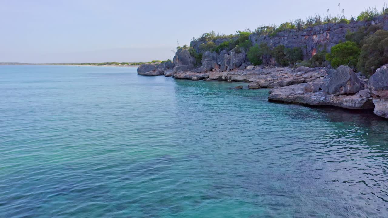 vuelo aéreo a lo largo de la hermosa bahía con costa rocosa y aguas turquesas del mar caribe