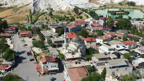 vista aérea de arriba hacia abajo de una pequeña ciudad con edificios residenciales en pamukkale turquía y colinas montañosas ricas en minerales en la distancia