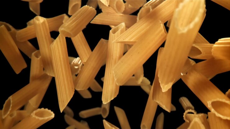 Primo piano di penne che cadono al rallentatore su sfondo nero