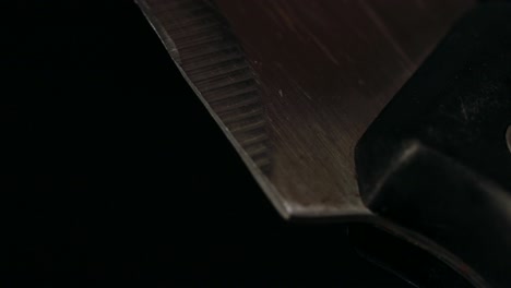 kitchen knife close up, black background, slow camera tilt