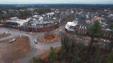 aerial pull away of small town shops and roundabout in front of suburban area at moss rock preserve in hoover, alabama