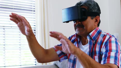 Senior-man-using-virtual-reality-headset-in-living-room-4k