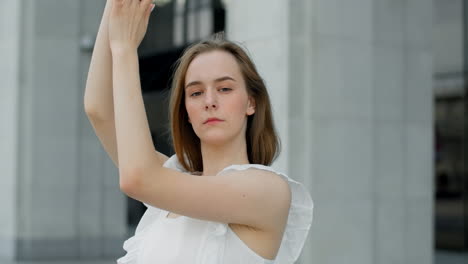 woman in a white dress outside a modern building