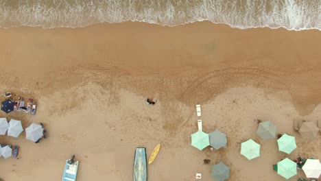 Vista-De-Arriba-Hacia-Abajo-De-Sombrillas-En-La-Orilla-Con-Olas-Salpicadas-En-La-Playa-De-Yelapa,-Jalisco,-México---Toma-Aérea-De-Drones