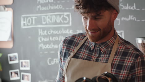 happy barista man serving customers buying coffee in busy cafe enjoying friendly service