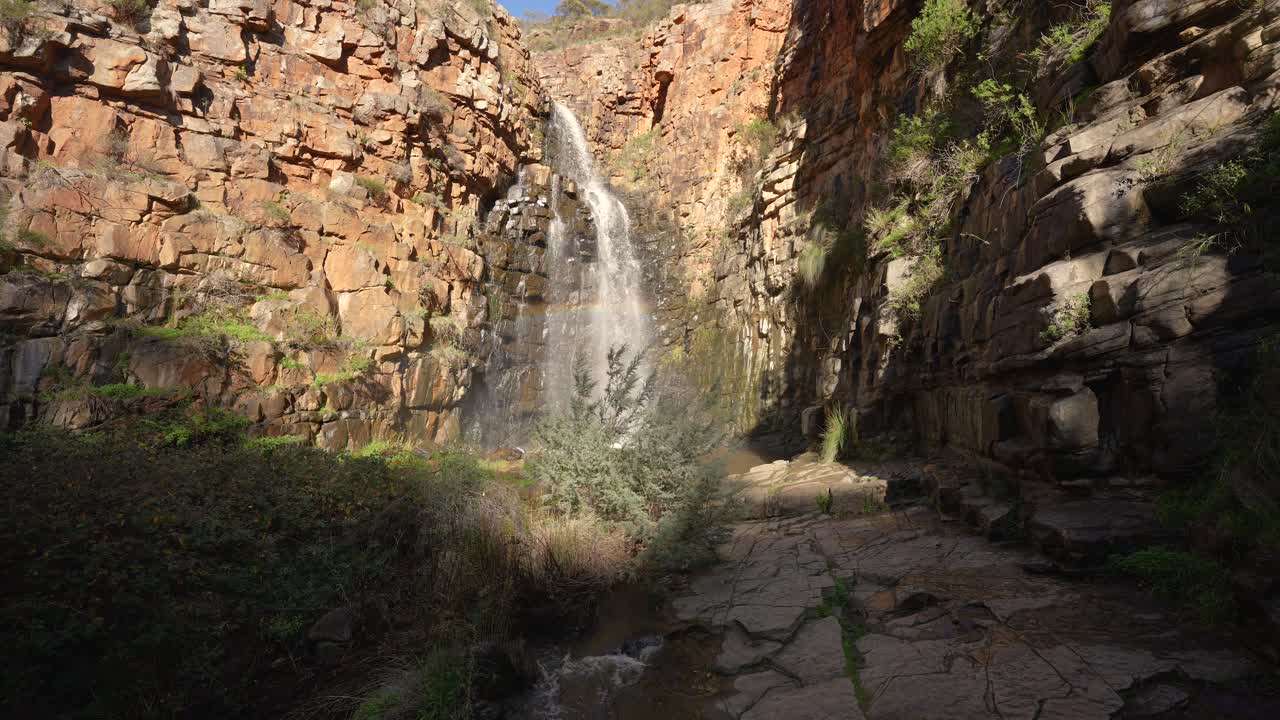 cascada que cae con una hermosa luz del sol y un arco iris en el medio