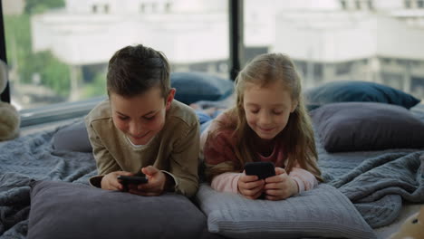 Niños-Complicados-Y-Adictivos-Juegos-Móviles.-Hermanos-Jugando-En-Teléfonos-Inteligentes-En-Casa.