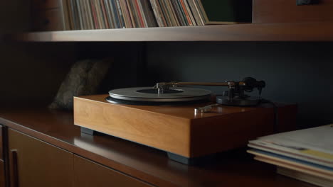 close-up of a turntable and vinyl records on a wooden shelf