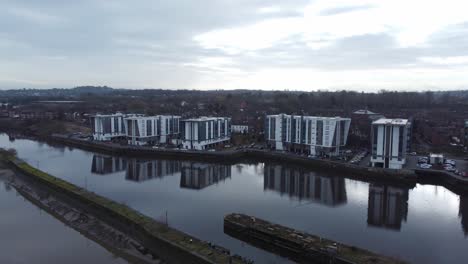 early morning aerial view riverside waterfront contemporary apartment office buildings canal regeneration real estate tracking dolly left