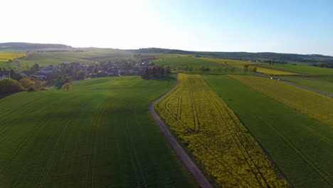 Drone-flight-over-fields-with-car-driving-by