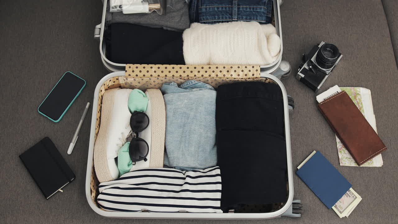 Open suitcase packed with travel essentials