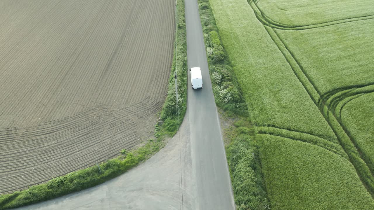 Delivery Van On The Way To Deliver Parcel Driving In The Narrow Irish Road Along The Wheat Fields