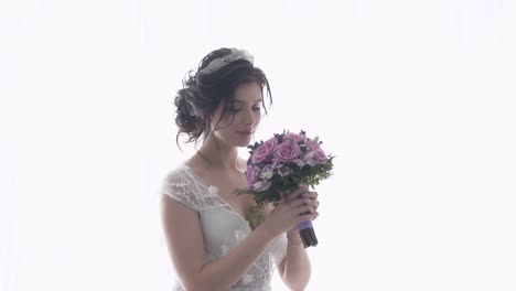 slow motion young woman in wedding dress holds bouquet