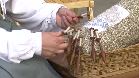 closeup-of-old-woman-making-bobbin-lace-with-her-hands,-detail-shot-of-braiding-thread