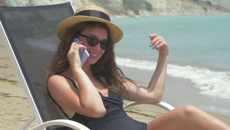 mujer feliz en la playa hablando por teléfono