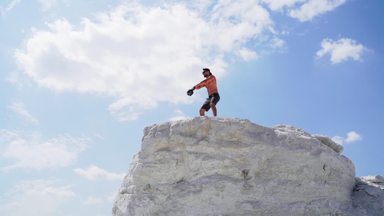 Sportive man with dumbbell. Athletic man doing workout routine on nature