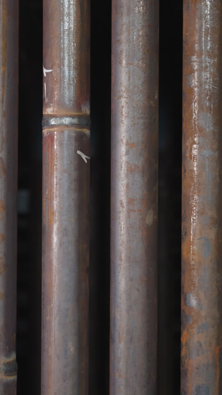 Metal pipes row with welding seams in factory storehouse closeup. Tubes stand in metalwork factory workshop. Heat exchanger equipment for gas and plumbing systems
