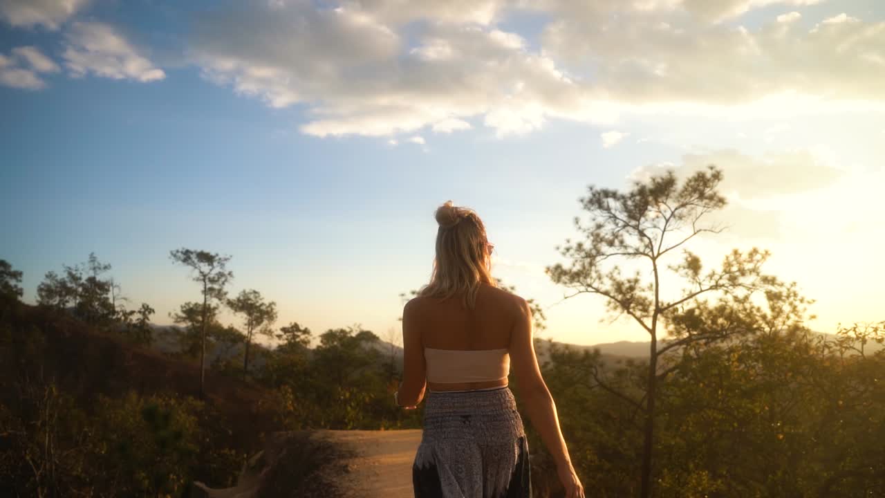 hermosa mujer rubia vestida de verano camina balanceando sus caderas entre la atracción turística verde del cañón pai en un día de verano en tailandia