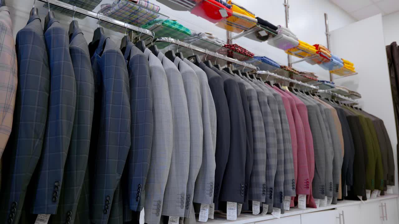 Beragam pilihan jas pria tergantung rapi di sebuah toko, menampilkan berbagai warna dan desain yang ideal untuk acara formal selama musim gugur.