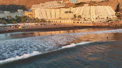 toma aerea en orbita al borde de la playa de taurito a mogan y donde se aprecian los hoteles de la zona