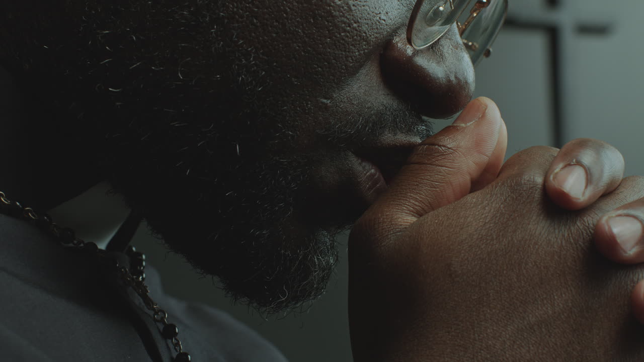 Close-Up View of Faithful Priest Praying Deeply in Church