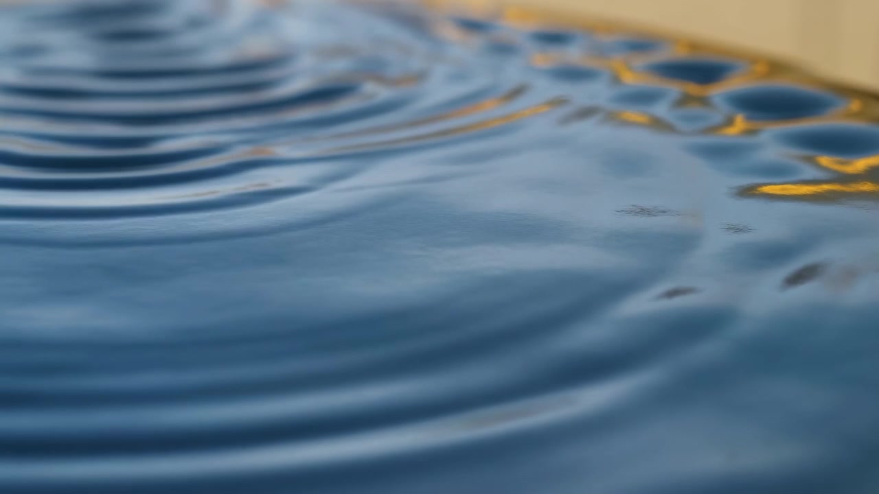 Sequenza cinetica attraverso il clip che mostra l'evoluzione delle increspature sull'acqua blu lucida in un bacino interno da una leggera perturbazione iniziale a una sovrapposizione in fase avanzata.
