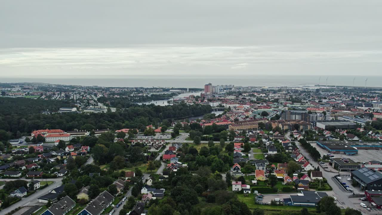 Veduta aerea in avanti di Falkenberg, Svezia, dove le aree residenziali verdi incontrano la costa del Kattegat. Calmo paesaggio urbano costiero scandinavo con vita urbana e orizzonte oceanico