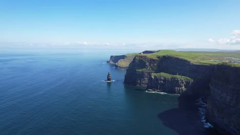 Drone-forward-shot-towards-sea-stack-near-Cliffs-of-Moher-on-bright-summer-day