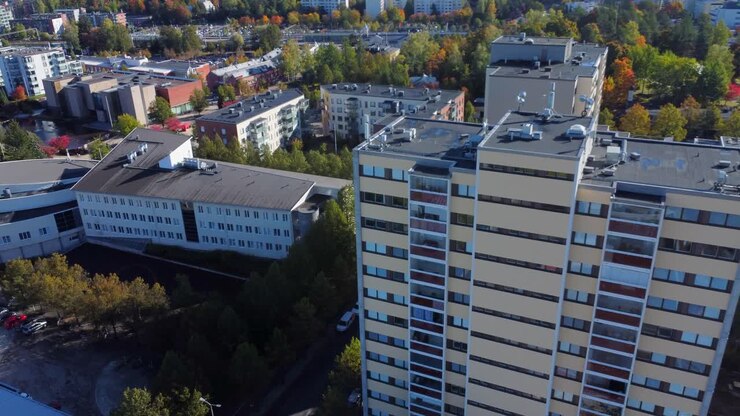 Imagens aéreas subindo um prédio de apartamentos amarelo em uma cidade do norte no outono