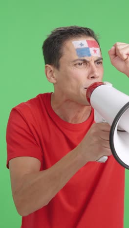 excited man with panamanian flag on face using a megaphone