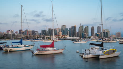 boats anchored in harbour and skyscrapers in background - timelapse zoom in