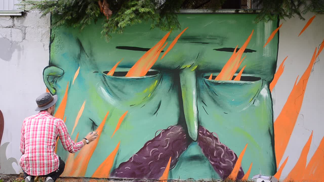 L'artista disegna graffiti su una recinzione, disegno di Kozak.