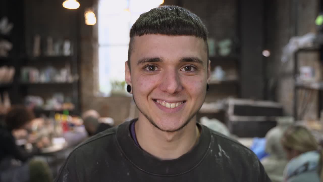 joven sonriendo en el estudio de cerámica