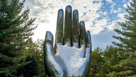 a large metal sculpture of a hand on top of a hill