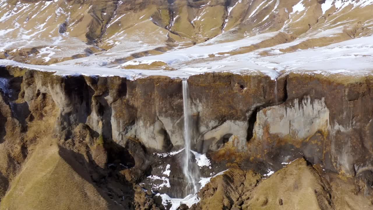 un dron 4k captura impresionantes imágenes aéreas de un acantilado rocoso islandés, acentuado por cascadas de agua para un espectáculo verdaderamente cinematográfico